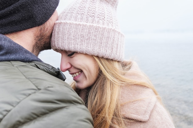 Foto tedere relatie van een stel, man en vrouw - meisje lacht in de armen van een man