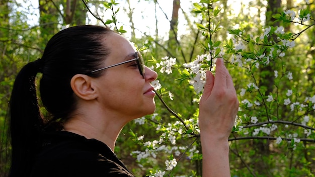 Tederheid zelf Een jonge vrouw ruikt het aroma in een bloeiende appeltuin in de lente