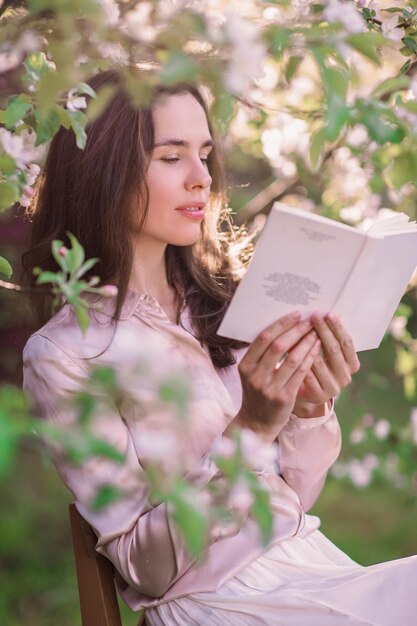 Tederheid zelf Een jonge vrouw ruikt het aroma in een bloeiende appeltuin in de lente