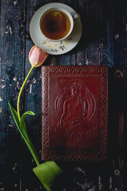 Tee cup op houten achtergrond met lente tulpen en wit vel