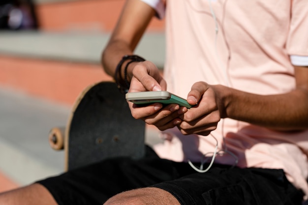 Teen boy listen to music, at a skatepark in Venice Beach, Los Angeles