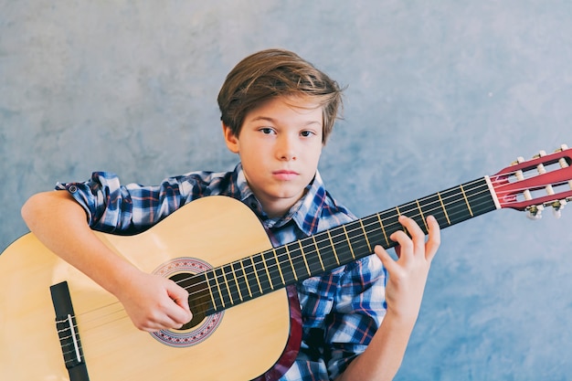 Photo teen boy playing acoustic guitar