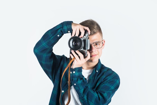 Teen boy wear casual shirt with retro photo camera isolated n white photographer