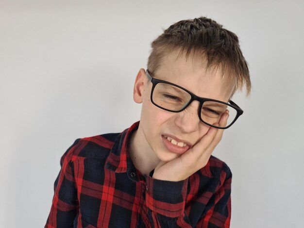歯がひどく痛むティーンエイジャーの少年