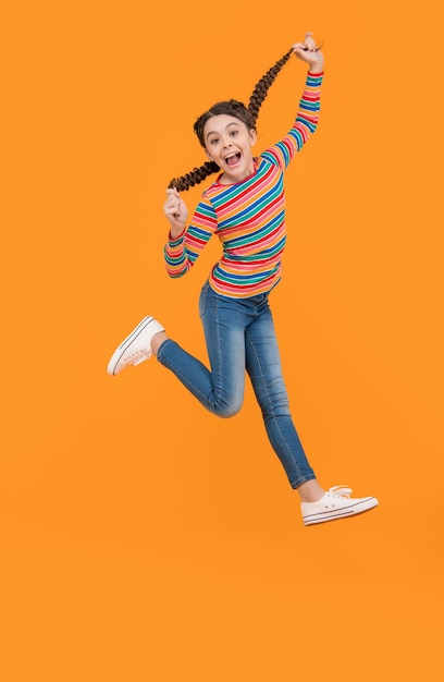 Teen braided girl jump isolated on yellow background teen girl with braided hair in studio