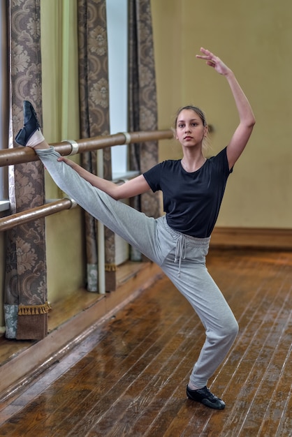 Teen doing exercises in the dance class at the bench