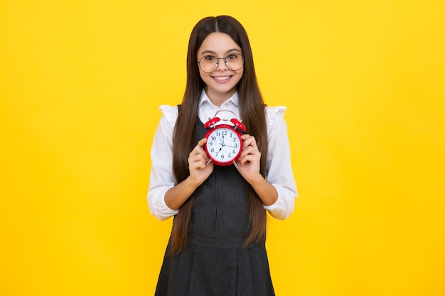 Девочка-подросток 12 13 14 лет смотрит на будильник Время для покупок распродаж Доброе утро время проверки Счастливое лицо девушки позитивные и улыбающиеся эмоции