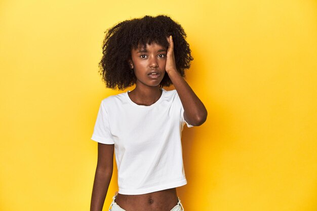 Teen girl in classic white Tshirt yellow studio backdrop being shocked