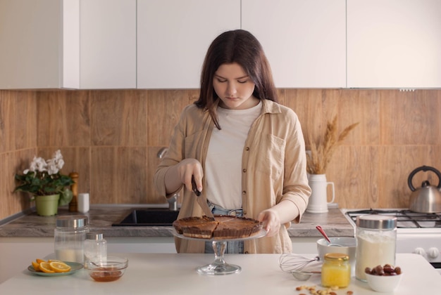 Teen girl cooking nuts pie in kitchen