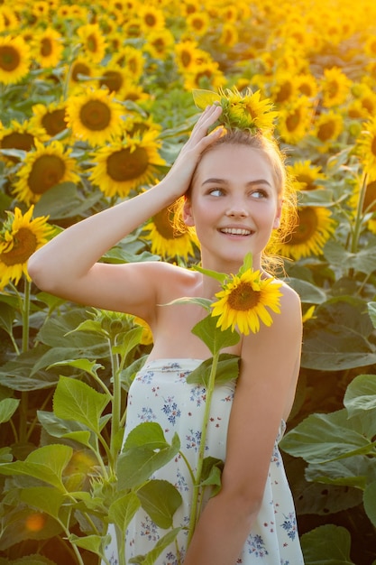 teen girl in a field of sunflowers at sunset