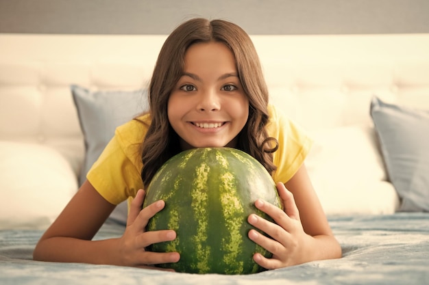 Photo teen girl having fun summertime happy child hold water melon watermelon at home