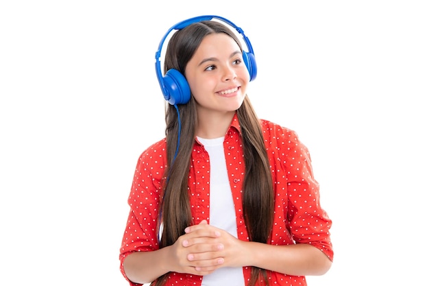 ヘッドフォンで 10 代の少女が音楽を聴くワイヤレス ヘッドセット デバイス アクセサリー子供は白い背景の上のイヤホンで音楽を楽しんでいます幸せな笑顔の 10 代の子供の女の子の肖像画