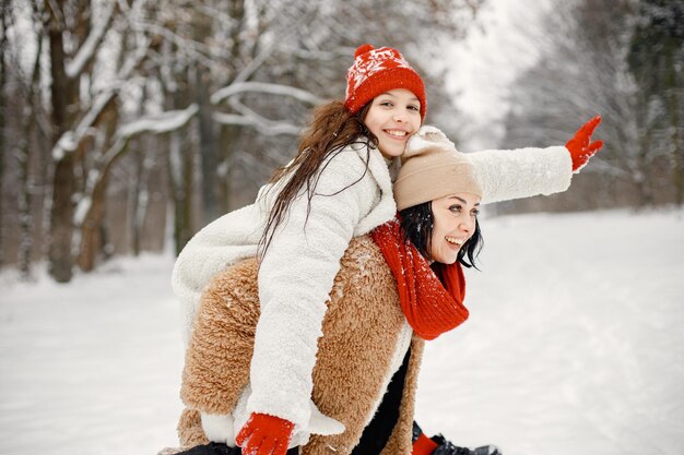 Девочка-подросток и ее мать веселятся в зимнем парке