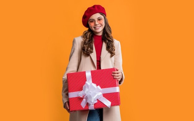 Teen girl hold present isolated on yellow background teen girl hold present in studio