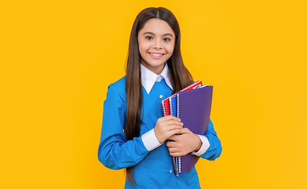 Teen girl holding workbook study at school lesson back to school knowledge and education college student girl teen girl gets high education education in school holding her workbook tightly