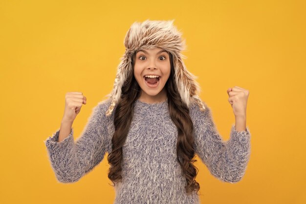 Teen girl in knitwear on yellow background portrait of child wearing warm clothes