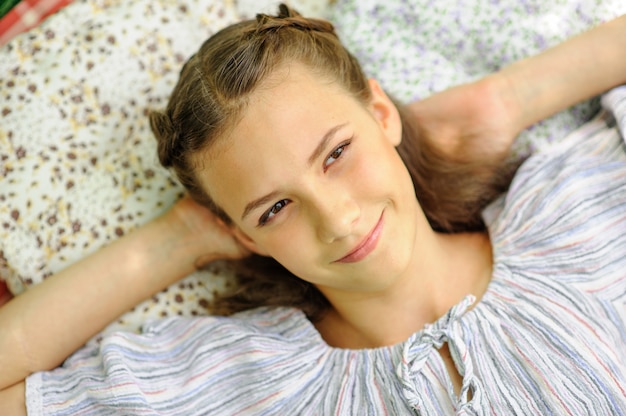 Teen girl lies on a pillow and looks up at the sky. The girl is dreaming about something.