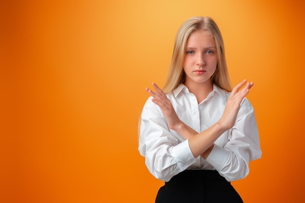 Photo teen girl making stop gesture on orange background