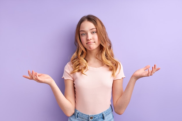 Foto ragazza teenager incomprensione, bella ragazza caucasica in abbigliamento casual che scrolla le spalle, isolata. non lo sa, gesticolando