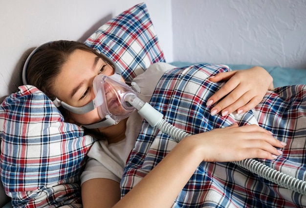 Foto ragazza adolescente con maschera d'ossigeno a letto