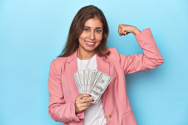 Photo teen girl in pink suit holding a handful of dollar bills