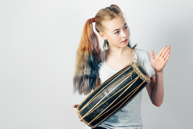 Ragazza teenager che suona la batteria etnica di mridangam