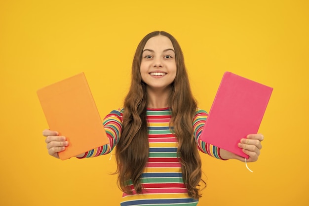Teen girl pupil hold books notebooks isolated on yellow background copy space Back to school teenage lifestyle education and knowledge