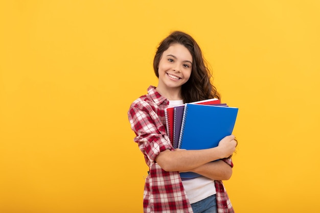 Photo teen girl ready to study happy childhood cheerful kid going to do homework with books smiling student education and knowledge high school schoolgirl with notebook back to school cute smile