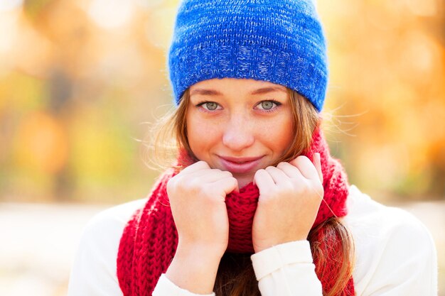 Teen girl in red scarf at autumn outdoor