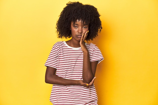 Photo teen girl in red striped tshirt yellow studio backdrop who is bored fatigued and need a relax day