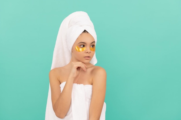 Teen girl in shower towel with golden patch copy space