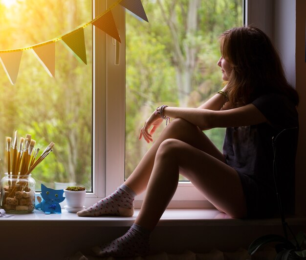 Teen girl sitting on a windowsill in the children's room