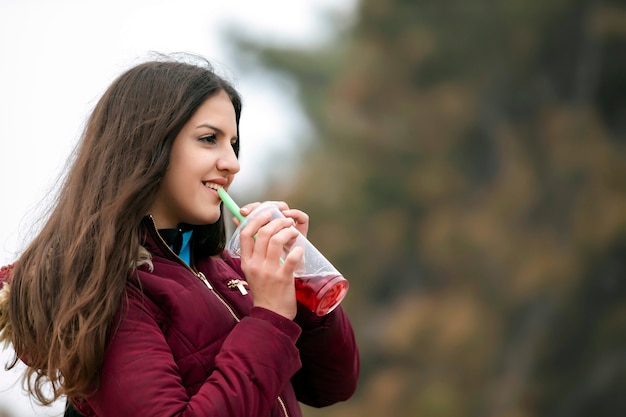 Ragazza teenager che sorride nel parco verde nella sera soleggiata di estate