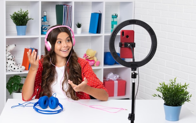 Teen girl speaking in front of camera for vlog Teenager working as blogger recording video blog Surprised face surprise emotions of teenager girl