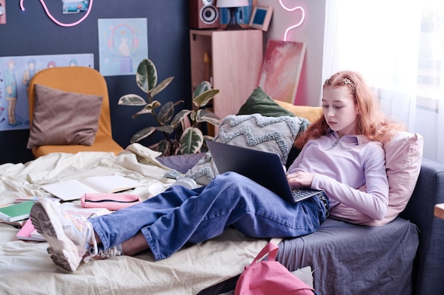 Teen girl surfing internet on laptop