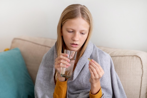 Photo teen girl taking medication at home