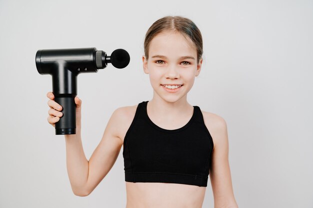 十代の少女はマッサージ銃を使用します