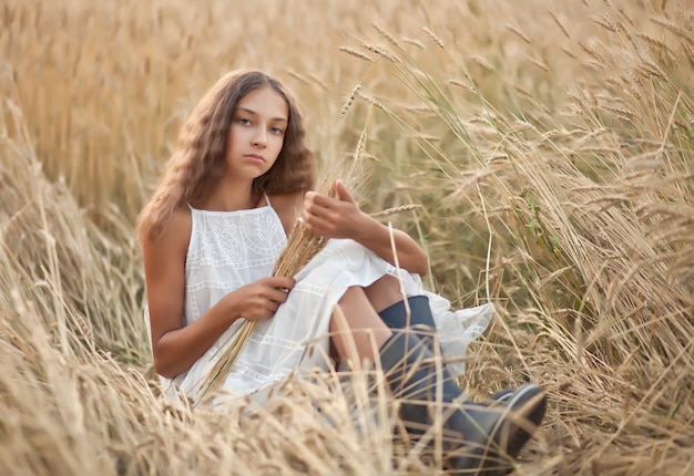 Teen girl in wheat field in a summer day.