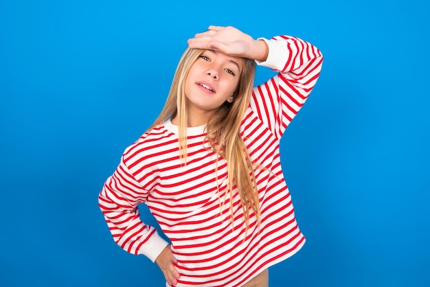 teen girl wiping forehead with hand making phew gesture expressing relief feels happy.