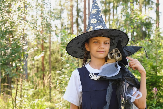 Teen girl in a witch costume in the park