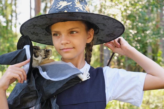 Photo teen girl in a witch costume in the park