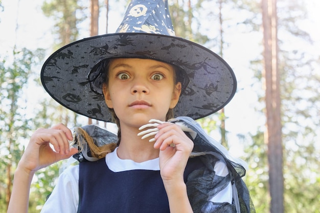 Ragazza teenager in un costume da strega nel parco