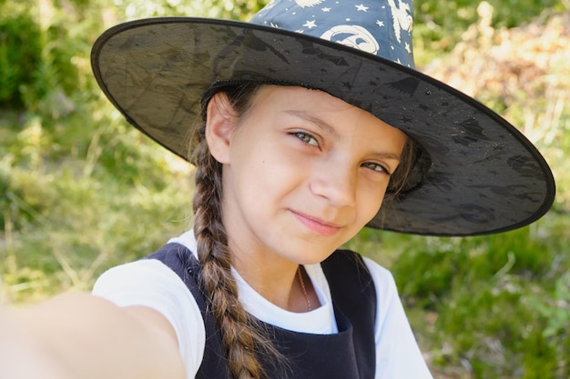 Teen girl in a witch costume in the park