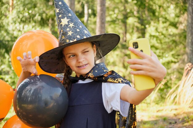 Teen girl in a witch costume in the park