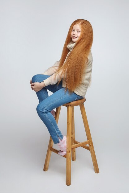 Фото Девушка с длинными рыжими волосами в студии на белом фоне