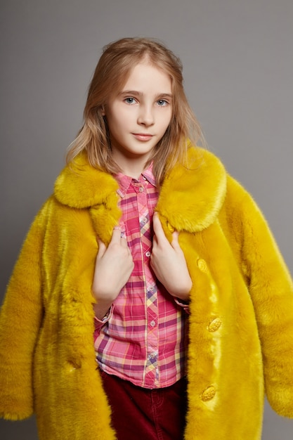 Teen girl in yellow faux fur coat, portrait