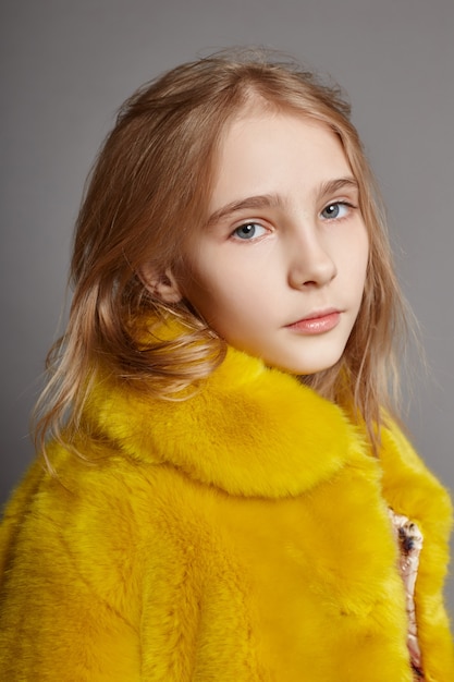 Teen girl in yellow faux fur coat, portrait