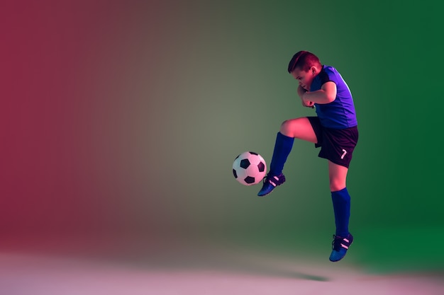 Teen male football or soccer player, boy. Gradient background