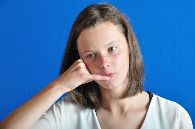 Photo teen miming a phone with her hand