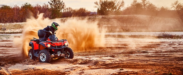 Foto adolescente che guida l'atv nelle dune di sabbia che fa un giro nella sabbia